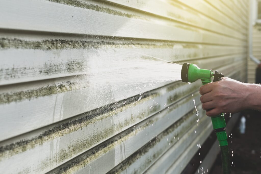 using garden hose to clean siding on house