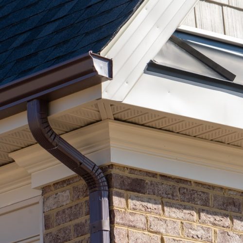 Closeup,View,Of,Dark,Brown,Gutter,System,With,White,Soffit